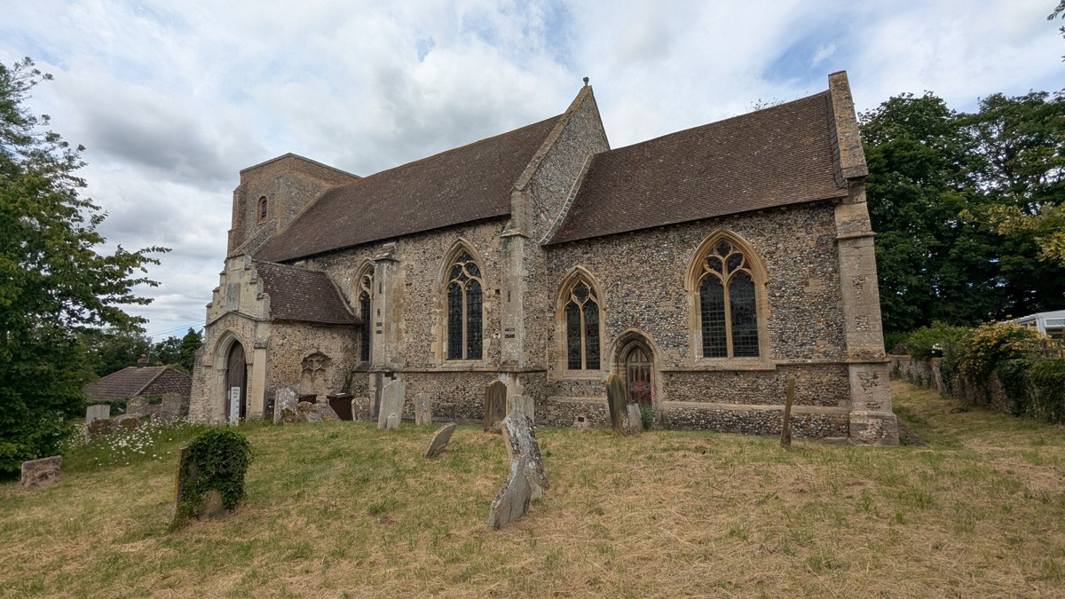 St Mary's Church, Kentford, seen from the churchyard: a flint church with a low west tower and a tiled nave roof.